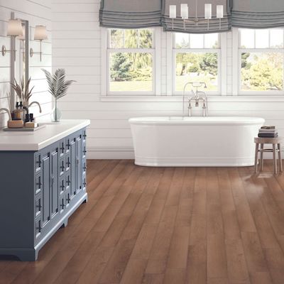 bathroom design with wood look vinyl foors and a tub
